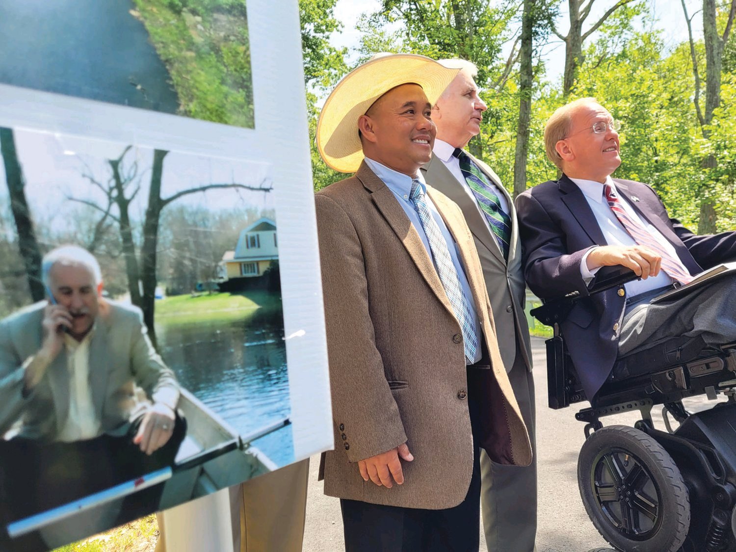 TWO IF BY SEA: In August, Phou Vongkhamdy, U.S. Sen. Jack Reed and U.S. Rep.
James Langevin stand near a poster, featuring a photo of Johnston Mayor Joseph M.
Polisena in a boat.